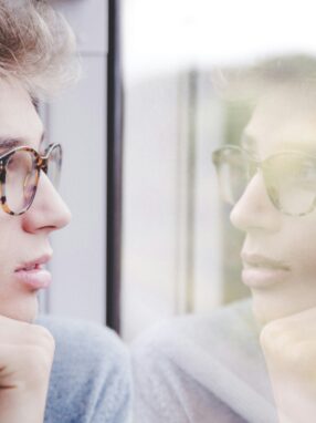 mężczyzna patrzący w zamyśleniu przez okno