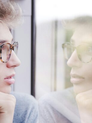 mężczyzna patrzący w zamyśleniu przez okno