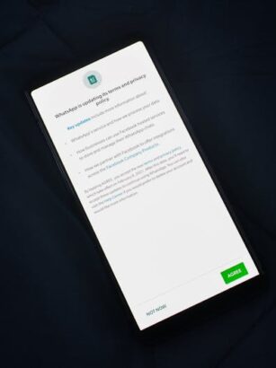 Smartfon z wyświetlonym powiadomieniem o aktualizacji polityki prywatności WhatsApp.