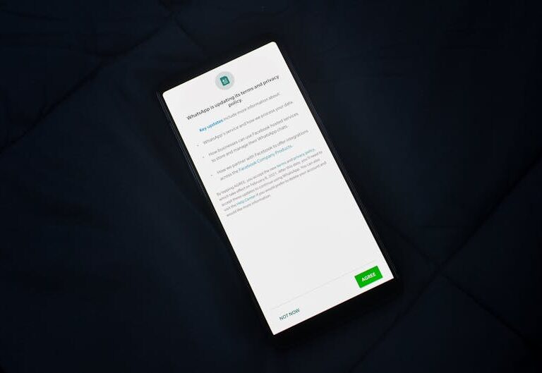 Smartfon z wyświetlonym powiadomieniem o aktualizacji polityki prywatności WhatsApp.