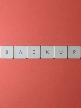 Białe klawisze z literami układające się w słowo „BACKUP” na czerwonym tle.