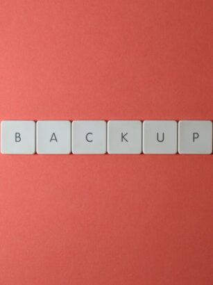 Białe klawisze z literami układające się w słowo „BACKUP” na czerwonym tle.
