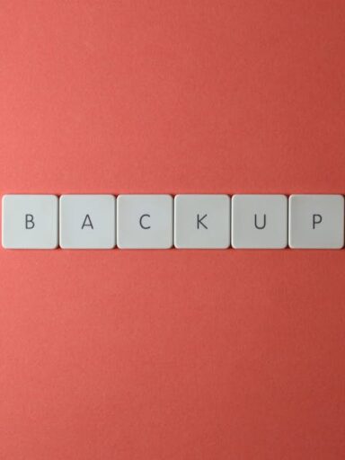 Białe klawisze z literami układające się w słowo „BACKUP” na czerwonym tle.
