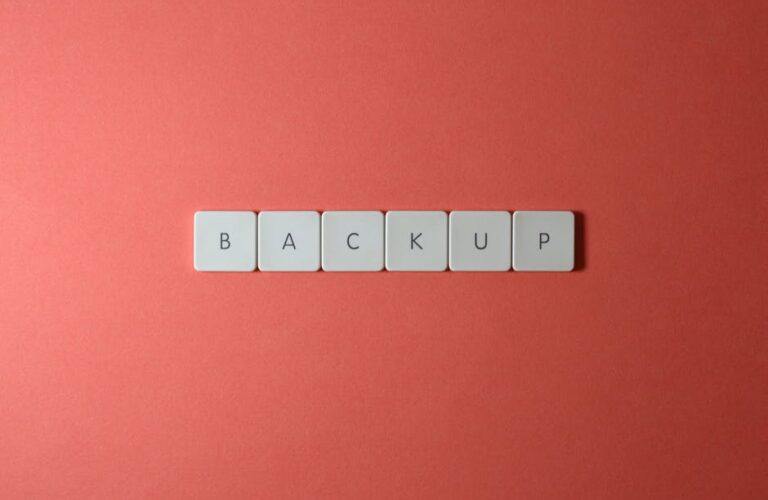 Białe klawisze z literami układające się w słowo „BACKUP” na czerwonym tle.
