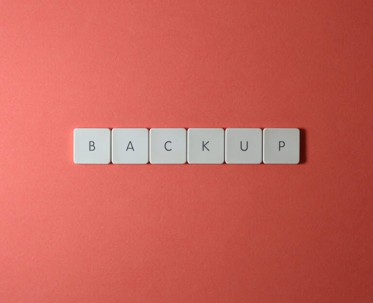 Białe klawisze z literami układające się w słowo „BACKUP” na czerwonym tle.
