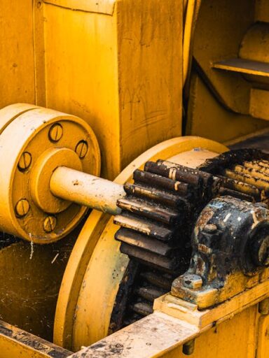 Zardzewiałe koła zębate i mechanizmy starej żółtej maszyny przemysłowej.