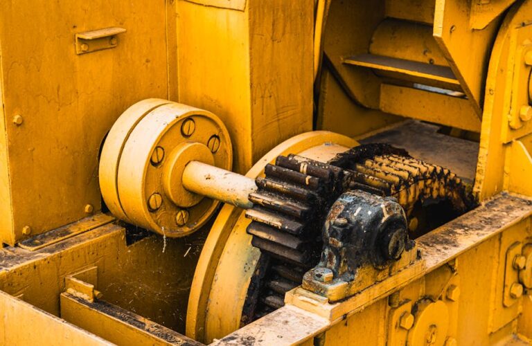 Zardzewiałe koła zębate i mechanizmy starej żółtej maszyny przemysłowej.