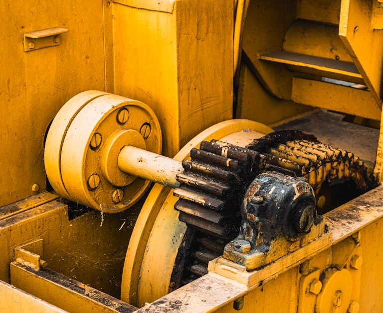 Zardzewiałe koła zębate i mechanizmy starej żółtej maszyny przemysłowej.