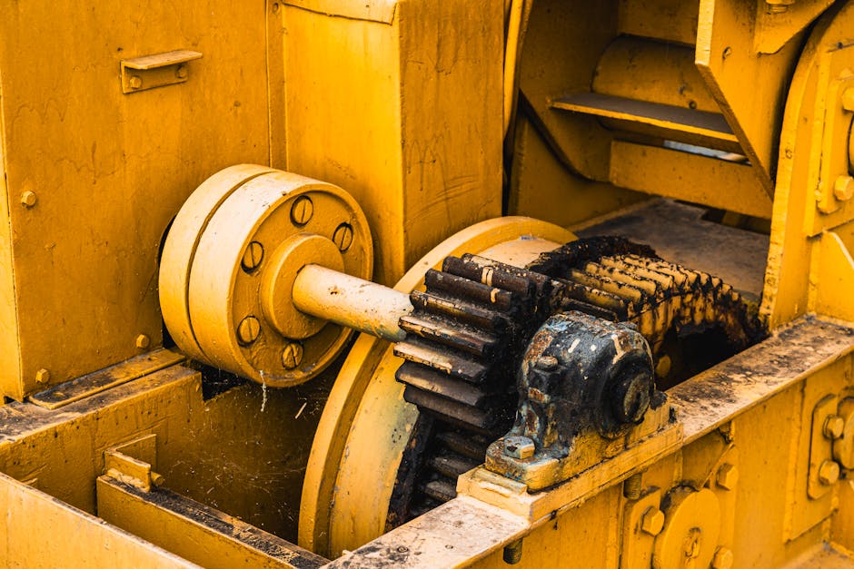 Zardzewiałe koła zębate i mechanizmy starej żółtej maszyny przemysłowej.