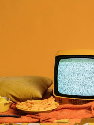 stary mały telewizor i przekąski na pomarańczowym tle