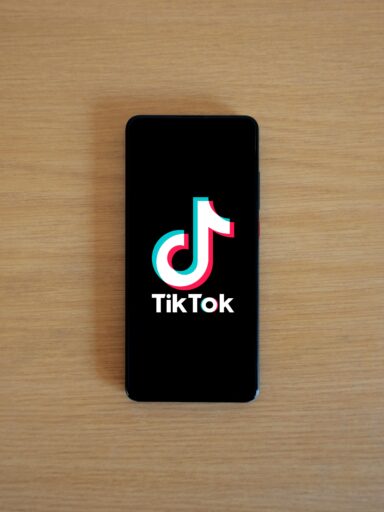 smartfon z otwartą aplikacją tiktoka leżący na stole